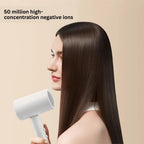 Woman with long, straight hair holding a white hair dryer against a beige background