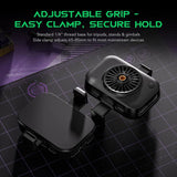 A black adjustable tripod grip accessory with a small built-in fan, shown alongside its matching black clamp base on a dark gridded mat. Green text at the top reads 'ADJUSTABLE GRIP - EASY CLAMP, SECURE HOLD' with smaller descriptive copy.